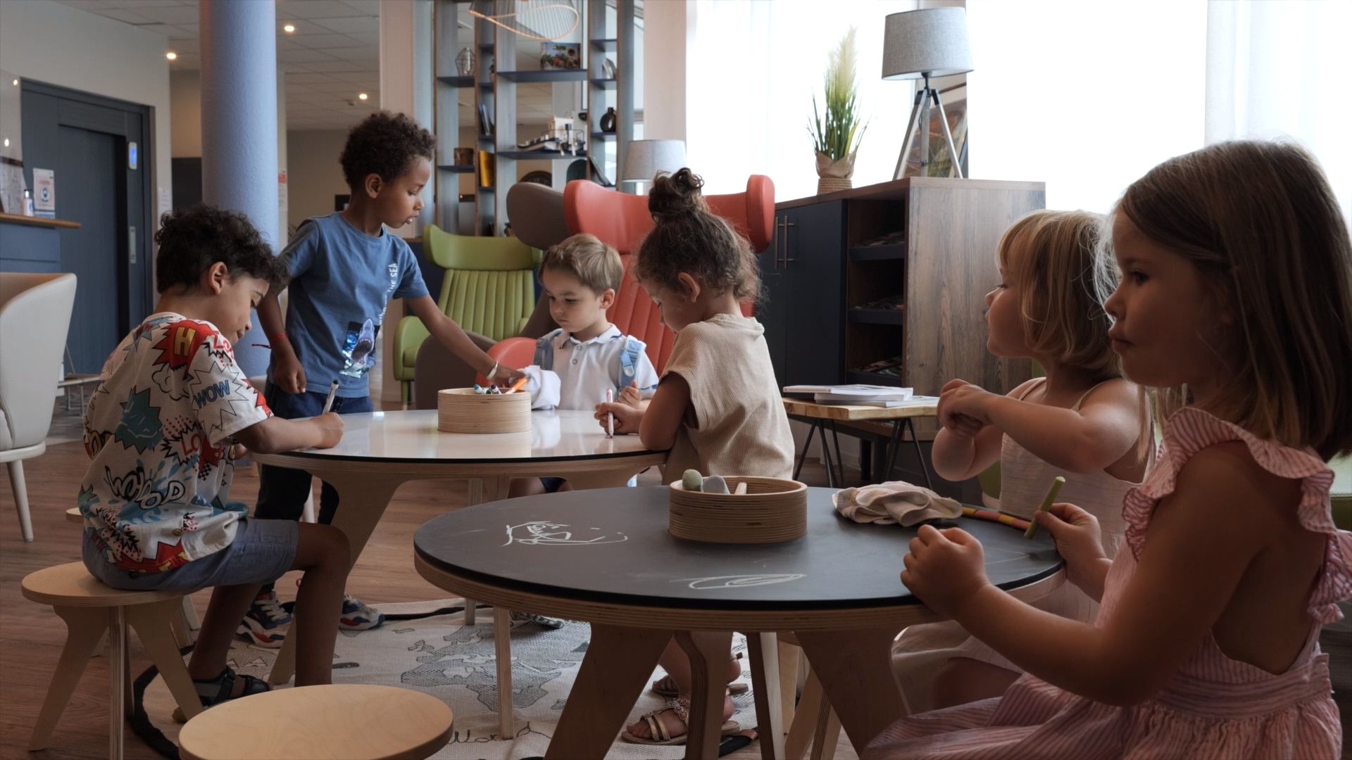 Children play on the Drawin'table, a piece of contemporary architectural furniture